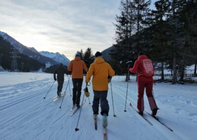 Four people cross-country skiing in Vermiglio in Val di Sole, Trentino, Italia