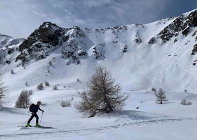 Ski mountaineering (skimo) in the Italian Dolomites with a skier climbing through a snowy mountain landscape