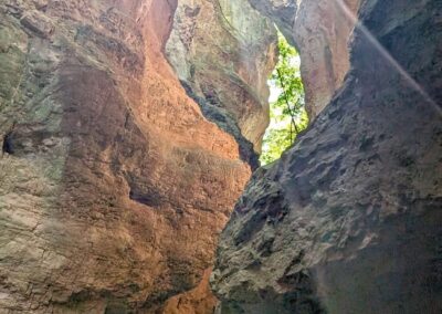 Kayaking through a narrow rocky gorge with sunlight shining between the cliffs on Lake Santa Giustina