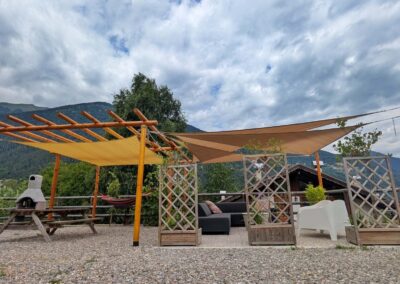 Outdoor seating area at Villa Meledrio with pergola, sun shades, barbecue and mountain views