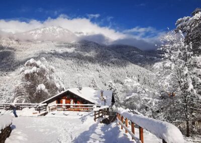 Snow-covered Villa Meledrio in Dimaro with winter mountain scenery in Val di Sole