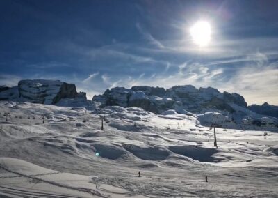 Sunny ski slopes with mountain peaks and ski lifts in Ski Area Campiglio Dolomiti di Brenta