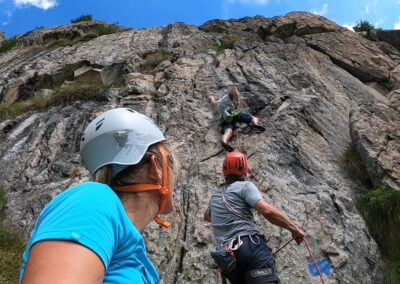 Rock climbing on a steep mountain wall with climbers using ropes and safety equipment in the Stelvio National Park, Italian Alps
